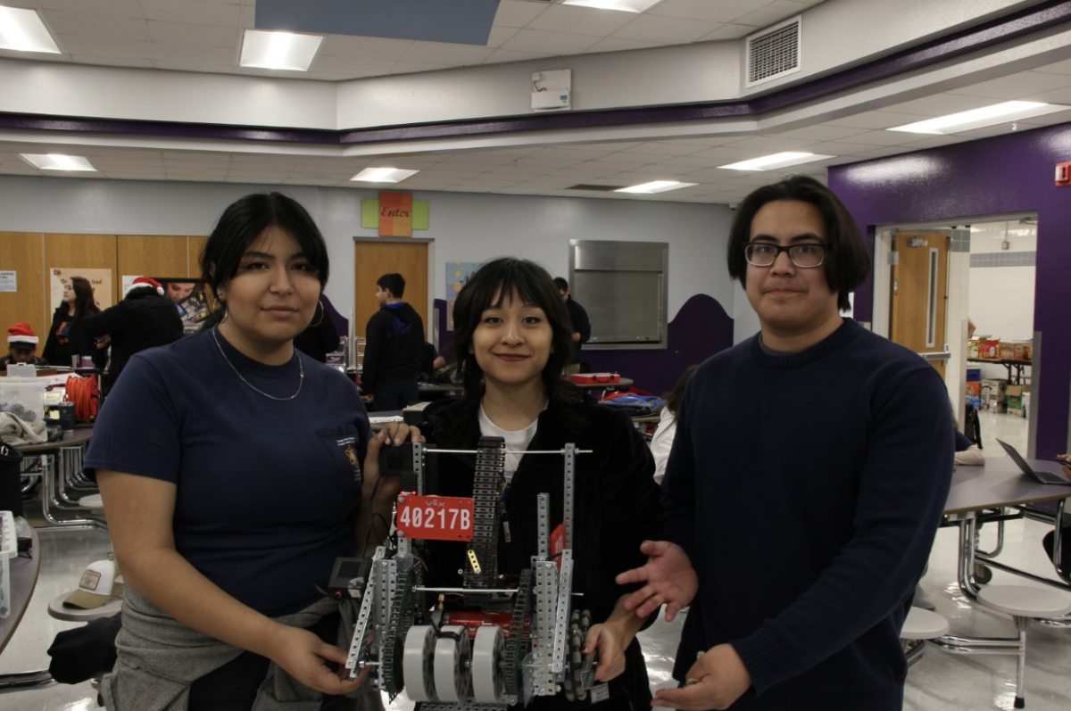 Senior team builders Julianna Yepez, and Miranda Galindo hold the robot ”Not Gary” with senior coder Santiago Diaz, moments before their first match.